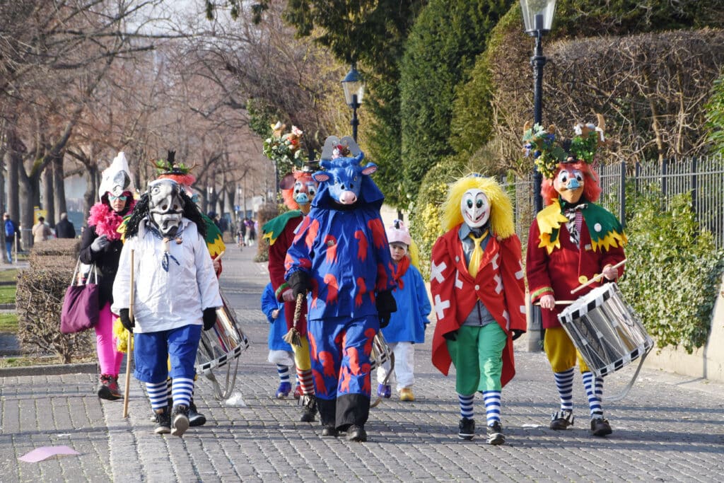 Adults in Halloween costumes marching in a Halloween costume parade.